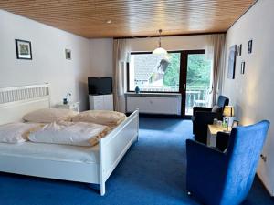 1 dormitorio con 1 cama, 1 silla y 1 ventana en Schwarzwaldblick, en Triberg