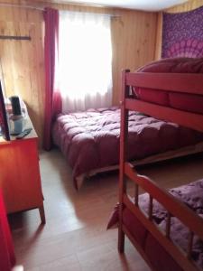a bedroom with two bunk beds and a window at Cabaña Agradable in Pucón