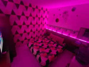 a purple room with a bed with pink lights at RDTROOM At Aeropolis in Teko