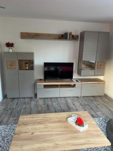 een woonkamer met een tafel en een televisie bij Ferienwohnung Starennest in Thermalbad Wiesenbad