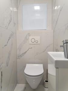 a white bathroom with a toilet and a sink at Tabáň Luxury apartment (city center & free parking) in Nitra