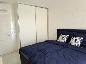 a bedroom with a blue bed and a closet at Tabáň Luxury apartment (city center & free parking) in Nitra