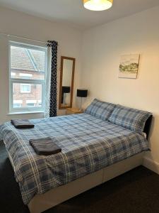 a bedroom with a bed with two towels on it at Luton Home near Airport Private & Shared Bathroom Option in Luton