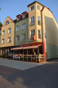 a tall building with a restaurant in front of it at Gościniec Jantar in Giżycko