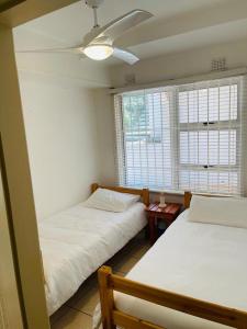 a bedroom with two beds and a ceiling fan at Ramsgate Beach house in Margate