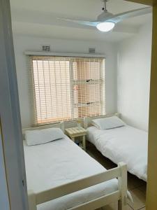 two beds in a room with a window at Ramsgate Beach house in Margate +2 photos