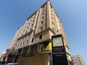 a tall building with a sign in front of it at Sendan Residence in Dammam
