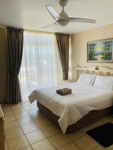 a bedroom with a large white bed with a fan at Ramsgate Beach house in Margate