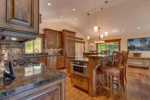 a kitchen with wooden cabinets and a island with bar stools at Hawk's Peak at Tahoe Donner in Truckee