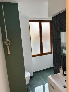 La salle de bains est pourvue de toilettes, d'un lavabo et d'une fenêtre. dans l'établissement Katrine, à Saint-Étienne