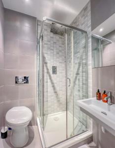 a bathroom with a shower and a toilet and a sink at Central London Apartment Camden in London