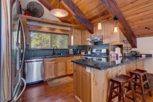 Una cocina con gabinetes de madera y refrigerador. en Edelweiss Retreat- Close to Lake and Ski Resorts- Pet Friendly- Hot Tub, en Tahoe City