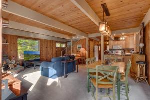 cocina y sala de estar con sofá azul y mesa en Cozy Wood Cabin- Updated- Hot Tub- Fireplace- Backs to Forest, en Carnelian Bay