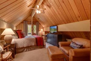 1 dormitorio con 1 cama y ventilador de techo en Cozy Wood Cabin- Updated- Hot Tub- Fireplace- Backs to Forest, en Carnelian Bay