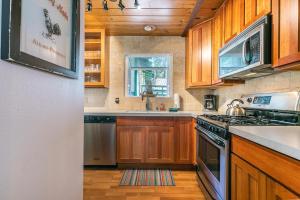 uma cozinha com armários de madeira e um forno com placa de fogão em Hidden Willow at Tahoe Park - Cozy 2 BR Cabin, Walk to Dining, Near Skiing em Tahoe City