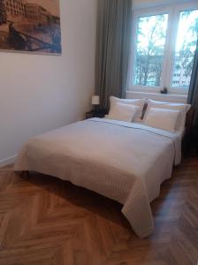 a bedroom with a bed with white sheets and a window at Apartament Mała Ogrodowa in Oborniki Śląskie