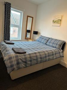 a bedroom with a bed with two towels on it at Luton Home near Airport Private & Shared Bathroom Option in Luton