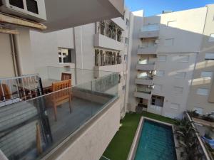 a balcony with a swimming pool and a building at Superbe appartement la Terrasse Hammamet Nord Mrezga in Hammamet