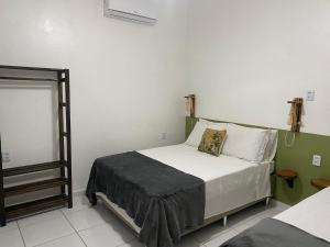una piccola camera da letto con un letto con lenzuola bianche di Villa Encantos do Paraíso 50mts da lagoa a Jijoca de Jericoacoara