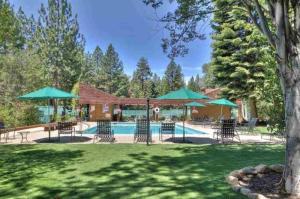 una piscina con sedie e ombrelloni in un cortile di North Shore Lakeside Condo #8 by Tahoe Getaways - Updated 3 Story Condo Near Palisades Resort w HOA! a Tahoe City