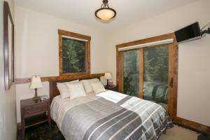 a bedroom with a bed and two windows at North Shore Bliss by Tahoe Getaways - 3 BR plus loft & Private Hot Tub in Carnelian Bay