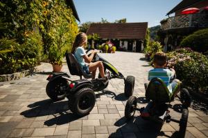 una mujer y un niño sentados en una moto de movilidad en Erlebnisbauernhof Tschom, en Sankt Kanzian