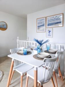 a white dining room with a white table and chairs at Casita Azul Las Arenas in Caleta De Fuste