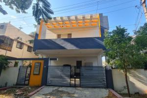 a blue and white house with a gate at Kamalam 2 BHK - Non AC in Coimbatore