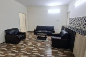 a living room with couches and chairs in a room at Kamalam 2 BHK - Non AC in Coimbatore