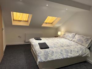 a bedroom with a large bed with two windows at Luton Home near Airport Private & Shared Bathroom Option in Luton
