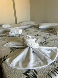 two beds with white towels on top of them at Piúma Palace Hotel in Piúma