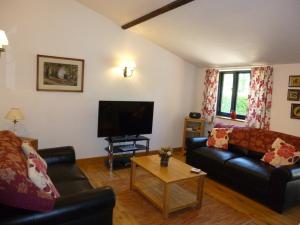 uma sala de estar com 2 sofás e uma televisão de ecrã plano em Withersdale Cross Cottages em Mendham