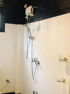 a shower in a bathroom with a light on the wall at Unakuruwa silent beach villa in Tangalle