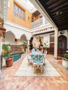 a patio with a table and chairs and a pool at Riad Elli Marrakech in Marrakesh