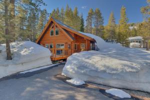 a log cabin in the woods covered in snow at Olympic Valley Hideaway - Newly Remodeled Cabin with Private Hot Tub in Olympic Valley