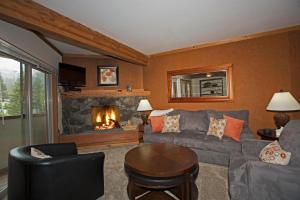 a living room with a couch and a fireplace at Palisades Tahoe Ski Condo - Remodeled 2 BR, Walking Distance to Lifts & Village in Olympic Valley