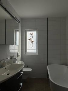 a bathroom with a sink and a tub and a window at Ferienwohnung Patrick in Amberg