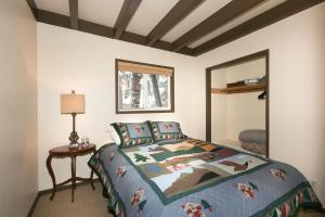 ein Schlafzimmer mit einem Bett, einem Tisch und einem Spiegel in der Unterkunft Pineland Chalet in Tahoe City - Classic Cabin Wood Fireplace Dog Friendly in Tahoe City