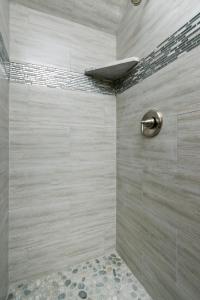 ein Bad mit einer Dusche und einer Steinmauer in der Unterkunft Pineland Chalet in Tahoe City - Classic Cabin Wood Fireplace Dog Friendly in Tahoe City + 10 Fotos