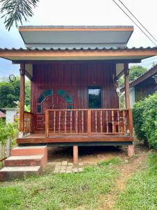 een huis met een groot houten terras met trappen bij Nuree Villa & Bungalow in Phra Ae beach