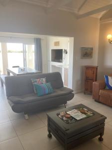 ein Wohnzimmer mit einem Sofa und einem Tisch in der Unterkunft Blessed at Ten76 holiday home in Witsand in Witsand