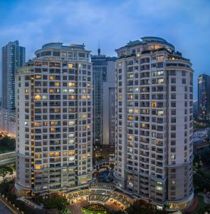 two tall buildings in a city at night at Somerset Grand Citra Jakarta in Jakarta