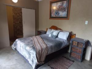 um quarto com uma cama e uma fotografia na parede em Kichaka Nyumba em Marloth Park