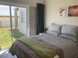 a bedroom with a bed and a sliding glass door at Blessed at Ten76 holiday home in Witsand in Witsand