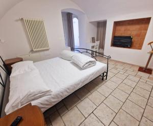 a bedroom with a white bed and a tv at SENTIERI DEL GARDA in Arco