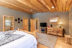 sypialnia z łóżkiem i telewizorem z płaskim ekranem w obiekcie Secret Garden Lodge - 4BR Walking Distance to the Lake, Hot Tub, Close to Ski Resorts! w mieście Carnelian Bay