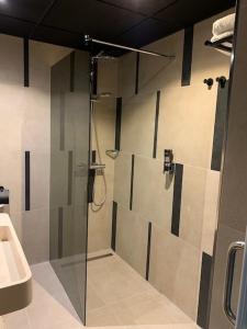 een douche met een glazen deur in de badkamer bij Leonardo Hotel Papendrecht in Papendrecht