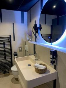 uma casa de banho com um lavatório, um espelho e um WC. em Leonardo Hotel Papendrecht em Papendrecht