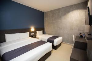 pokój hotelowy z 2 łóżkami i telewizorem w obiekcie 1 Hotel Signature w mieście Port Dickson