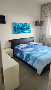 a bedroom with a bed with a blue comforter at Barzo Apartment in Rome